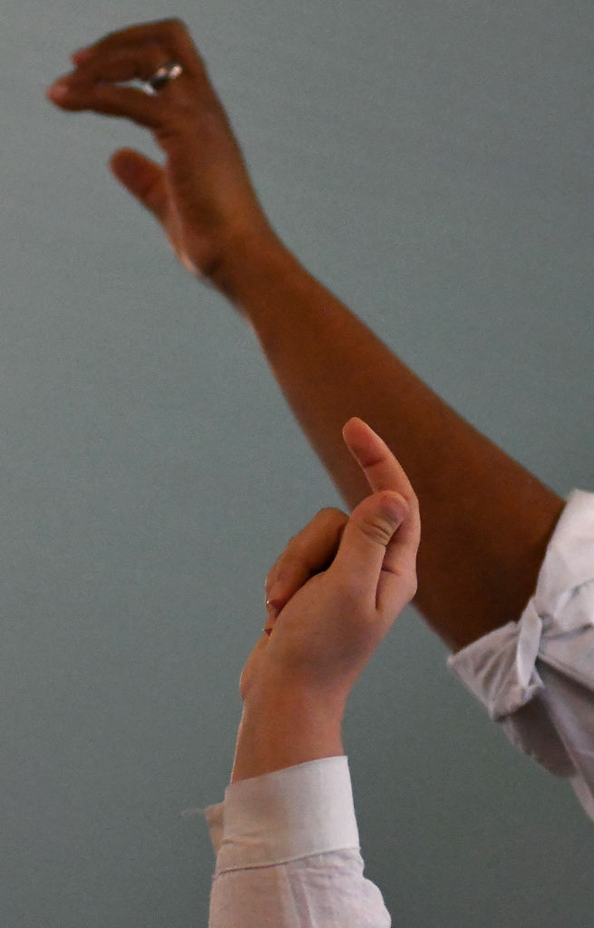 Cast members outstretch their arms during a production of "The Milly Project"